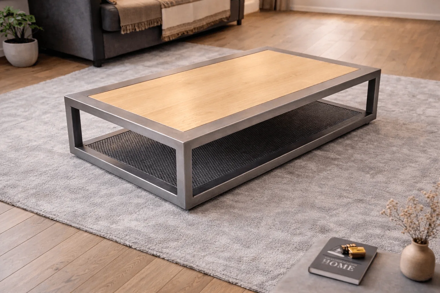 Table basse moderne en métal gris avec plateau en bois clair et espace de rangement inférieur sur tapis gris dans le salon, idéal pour apprendre comment choisir table basse.